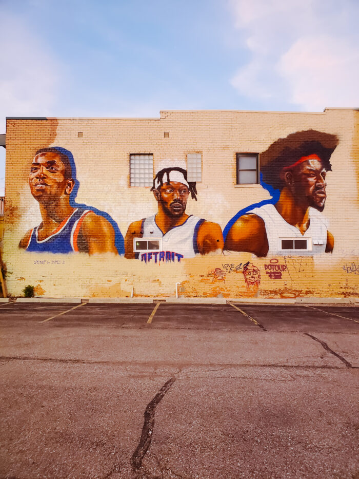 The "Path of Giants" mural features Detroit Pistons basketball players Isiah Thomas, Jerami Grant, and Ben Wallace. It's  located at 449 E Milwaukee Street in Detroit.