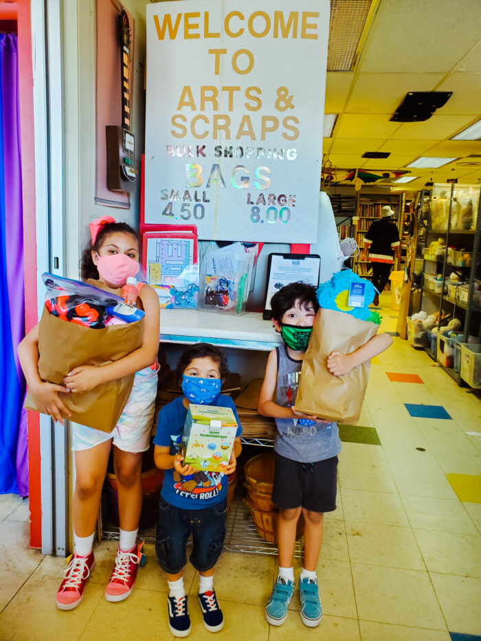 Three young children hold their shopping bags filled with goods at Arts and Scraps in Detroit.